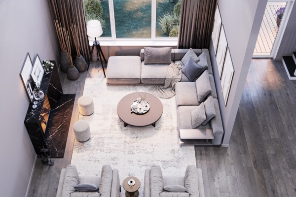 Wohnzimmer aus der Vogelperspektive mit grauem Ecksofa, rundem Couchtisch, schwarzem Marmorkamin und Blick in den Garten